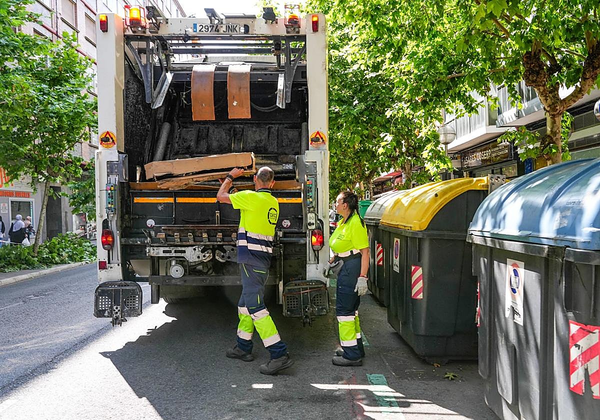 Operarios de limpieza recogen cartones en una céntrica calle vitoriana.