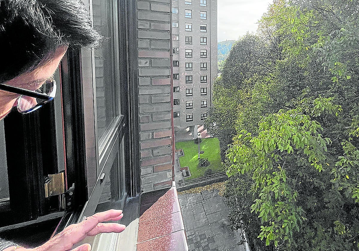 Marieli Guinea desde la ventana de su piso, que colinda con el patio del instituto Txurdinaga Behekoa, donde se encuentra la vegetación.