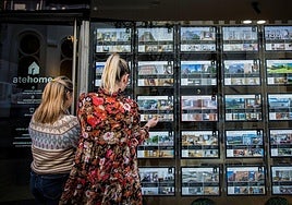 Dos mujeres observan los precios de una inmobiliaria en Bilbao.