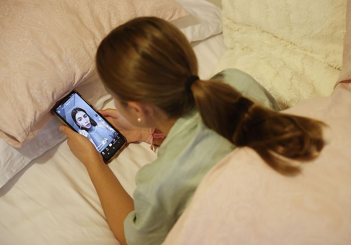 Una joven consulta su teléfono móvil.