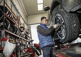 Un operario de Ruedas Miguel Araba coloca neumáticos de invierno a un vehículo.
