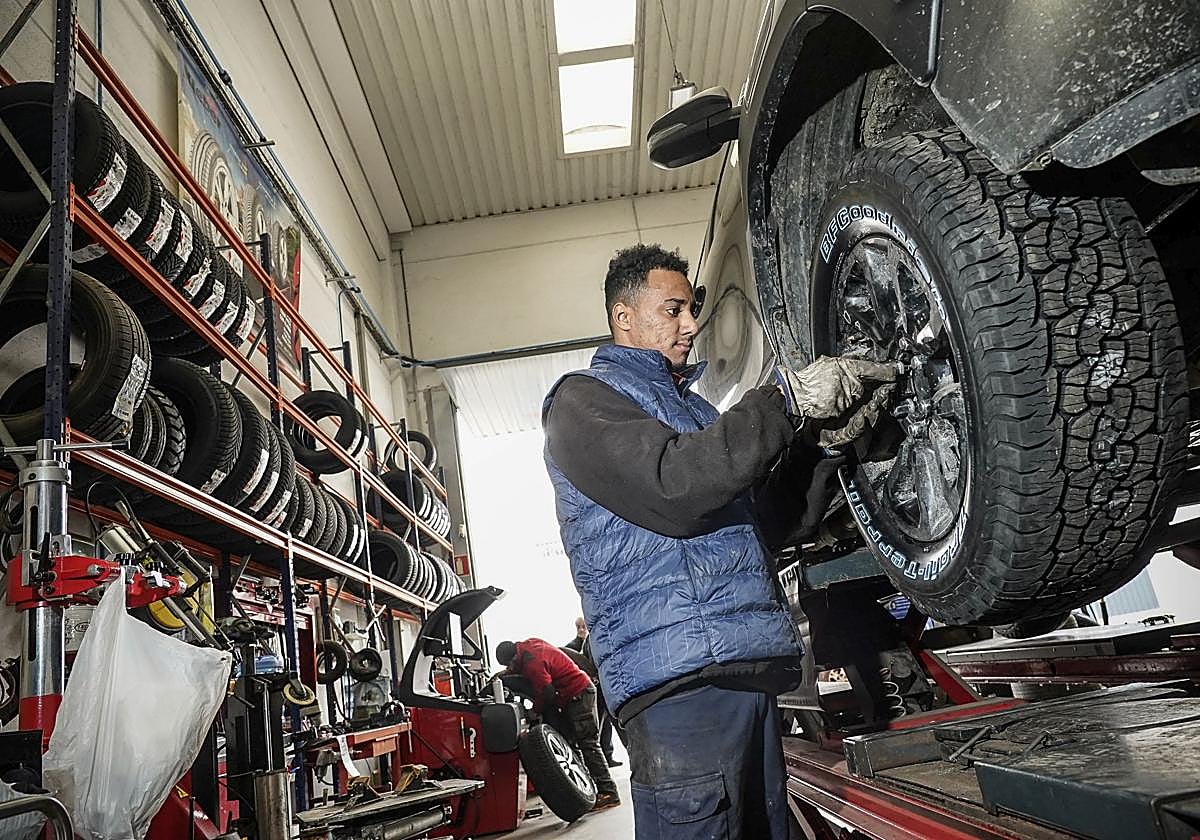 Un operario de Ruedas Miguel Araba coloca neumáticos de invierno a un vehículo.
