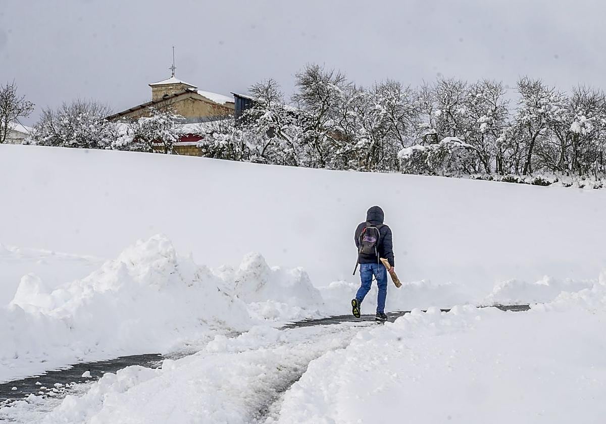 Un hombre cruza el paisaje nevado con el pan.