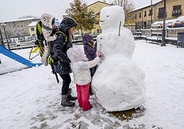 Una familia hace un muñeco de nieve en Lagrán