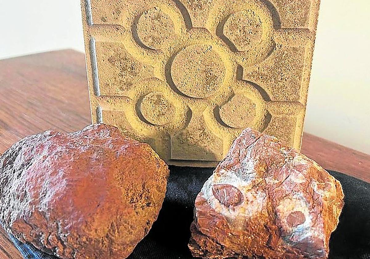 Un trozo de mineral Rojo Bilbao junto a una baldosa típica.