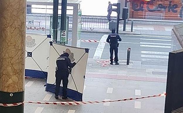 Efectivos de la Ertzaintza retiran el biombo colocado para proteger el lugar donde murió Kerman.