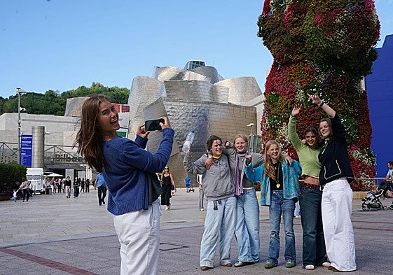 Un grupo de jóvenes posan junto al Guggenheim en Bilbao.