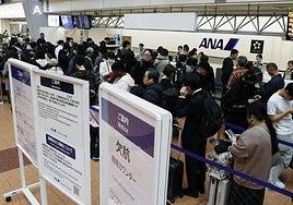 Los pasajeros hacen cola en el mostrador de cancelaciones de ANA (Japón) después de que la compañía anunciara retrasos.