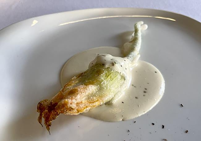 Flor de calabacín rellena de brandada y gárum de cabezas de anchoa y sardina, sobre un gazpacho de tomate a la brasa con unas gotas de whisky Laphroaig.