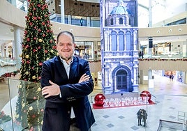 Óscar Valdivieso en la primera planta del centro comercial con la decoración navideña de fondo.