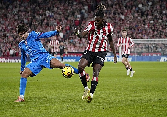 Nico Williams trata de hacerse con el balón ante el marcaje de Giuliano Simeone.