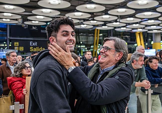 Patxi Cortazar saluda emocionado a su hijo Lucas recién aterrizado en el aeropuerto Adolfo Suárez Madrid-Barajas.