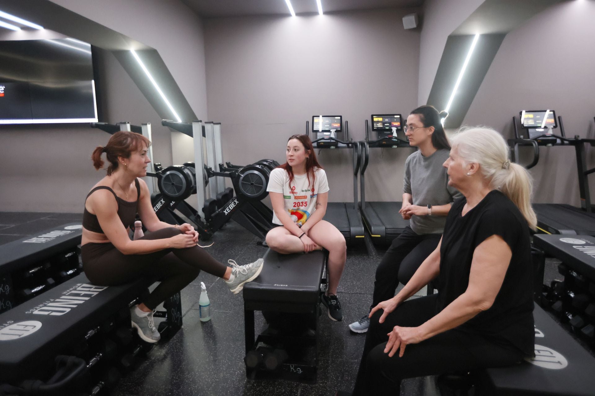 Un grupo de alumnas conversan con su monitora después de una clase en el gimnasio Being Fit.