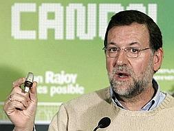 El presidente del Partido Popular, Mariano Rajoy, muestra una memoria electrónica tras firmar un manifiesto contra el canon digital aprobado por el Gobierno. /EFE