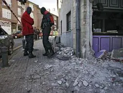 Agentes de la Ertzaintza rastrean la entrada de la sede socialista de Elgoibar, donde ha explotado un artefacto esta madrugada sin que se registraran heridos. /EFE