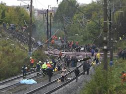 Operarios trabajando en la catástrofe, sobre las vías del tren. /REUTERS