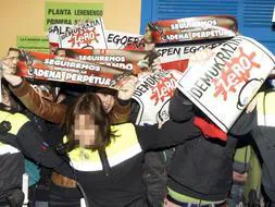 Policias municipales impiden el paso a un grupo de radicales que increparon al candidato socialista a lehendakari, Patxi López, y su esposa, Begoña,en el colegio de Bilbao donde votaron. / Efe