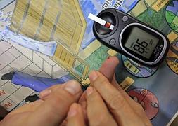 Una doctora muestra cómo hacer la prueba de control de azúcar en sangre a un enfermo de diabetes. / Efe