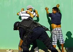 Las fuerzas de seguridad cachean a dos hombres en una calle de Apatzingán. / Héctor Guerrero (Afp)