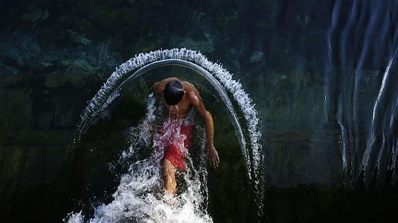 Un joven se refresca en el río contra el calor