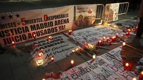 Pancartas y velas en la vigilia a las puertas del pabellón Madrid Arena 