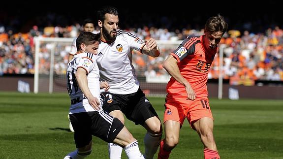 Piatti y Negredo luchan por el balón con Canales. 