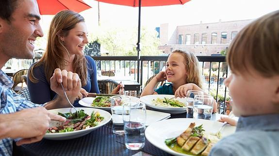 Una familia comiendo en un restaurante.