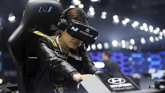 Una visitante prueba un simulador de realidad virtual en el Salón Internacional del Automóvil de Shanghái