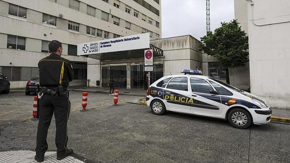 Un coche de policía ante el Complexo Hospitalario Universitario de Ourense (CHUO).