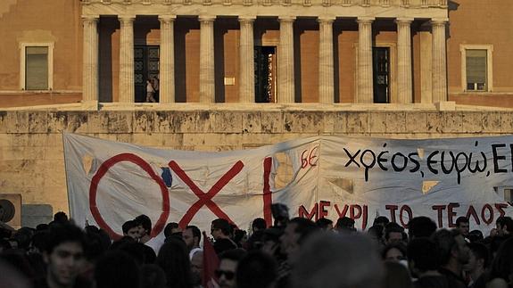 Varias personas participan en una protesta contra las políticas de austeridad en el Parlamento de Atenas.