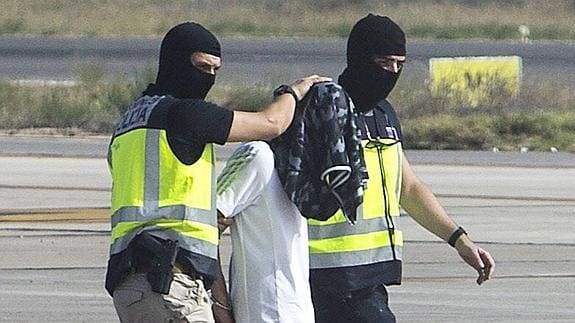 La policía española escoltan a un hombre, sospechoso de reclutar mujeres para el grupo yihadista armado Estado Islámico.