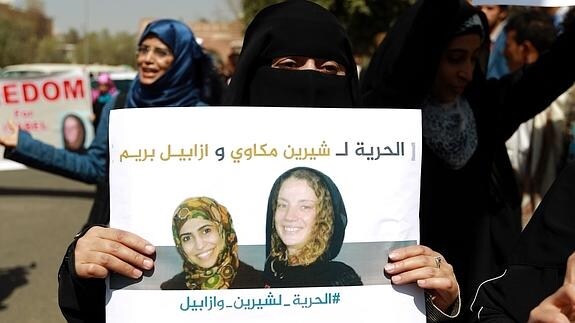 Una mujer yemení sostiene un cartel en el que aparecen Isabelle Prime y su intérprete. 