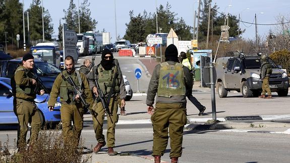 Varios soldados israelíes en un cruce próximo a la estación central de autobuses del asentamiento judío de Gush Etzion.
