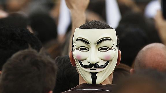 Un joven con una careta identificativa de Anonymous durante una manifestación. 