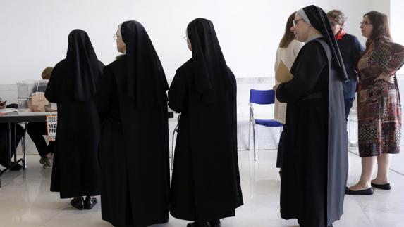 Varias monjas guardan cola para depositar su voto en un colegio de Santiago de Compostela.
