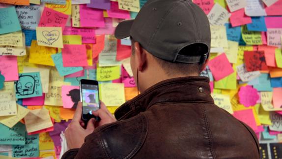 Un joven toma una imagen de uno de los pósit-