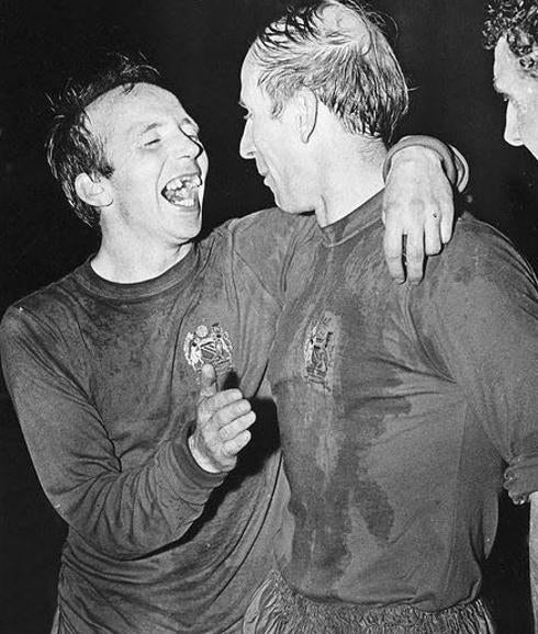 Nobby Stiles (i) abraza a Bobby Charlton. 