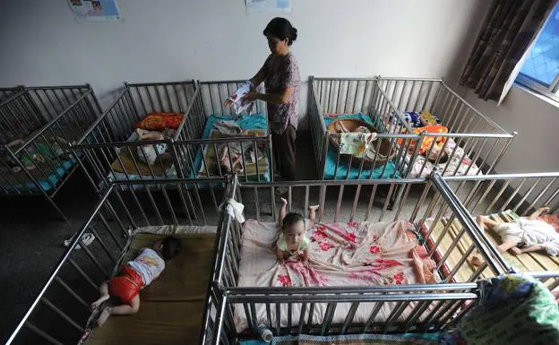 Una trabajadora social atiende a niños en un orfanato de China. 