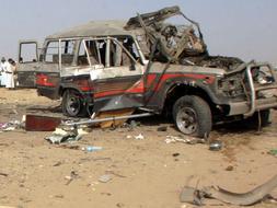 Restos del coche bomba y el vehículo en el que viajaban varios turistas españoles, tras el atentado que costó la vida a siete de ellos, en Yemen. /Reuters
