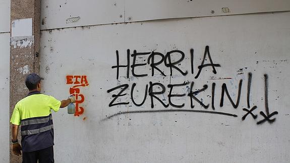 Un empleado municipal limpia una pintada a favor de ETA en una calle de Amurrio en 2013.