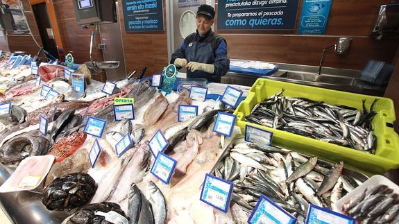 Una pescatera elimina las vísceras de una partida de anchoas para venderlas ya limpias.