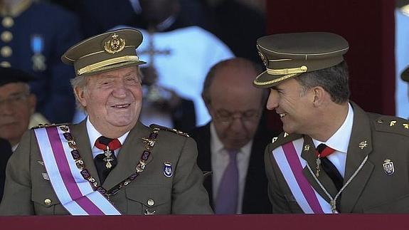 El Rey y el Príncipe, en un gesto de complicidad durante el acto en el monasterio de El Escorial de este martes..