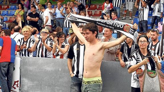 La afición blanquinegra acudió en masa a Langreo; muchos, como el chico que despliega su bufanda, se marcharon abatidos de Ganzábal.