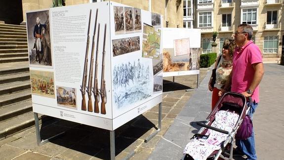 Una familia observa algunos paneles de la exposición dedicada al General Álava en la plaza de la Provincia