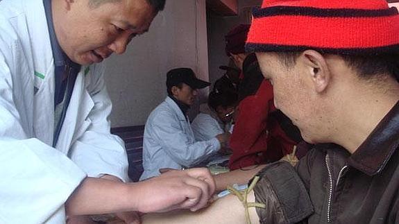 Un investigador chino extrae una muestra de sangre a un tibetano.