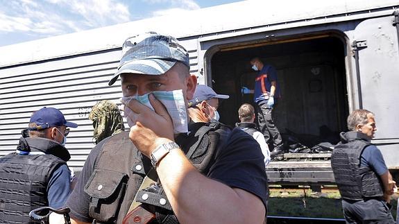 Un miliciano prorruso se cubre del hedor mientras las víctimas del vuelo malayo están retenidas en el tren frigorífico en Torez.