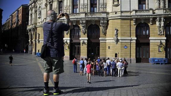 Un grupo de turistas contemplando el Teatro Arriaga en Bilbao.