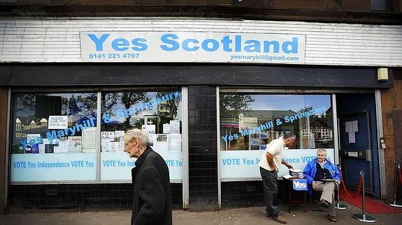 Un peatón camina frente a una oficina de la campaña del 'Si Escocia', en Glasgow.