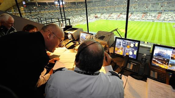 Un locutor habla con un compañero antes de un partido de fútbol.