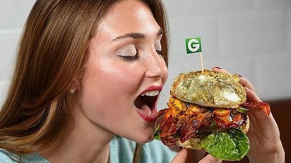 Una mujer a punto de dar un bocado a la 'Glamburguer'.